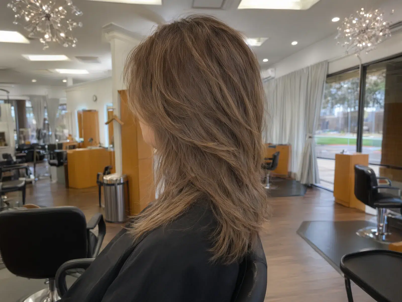 Caramel bronde lob, tousled, in the salon chair at Salon D