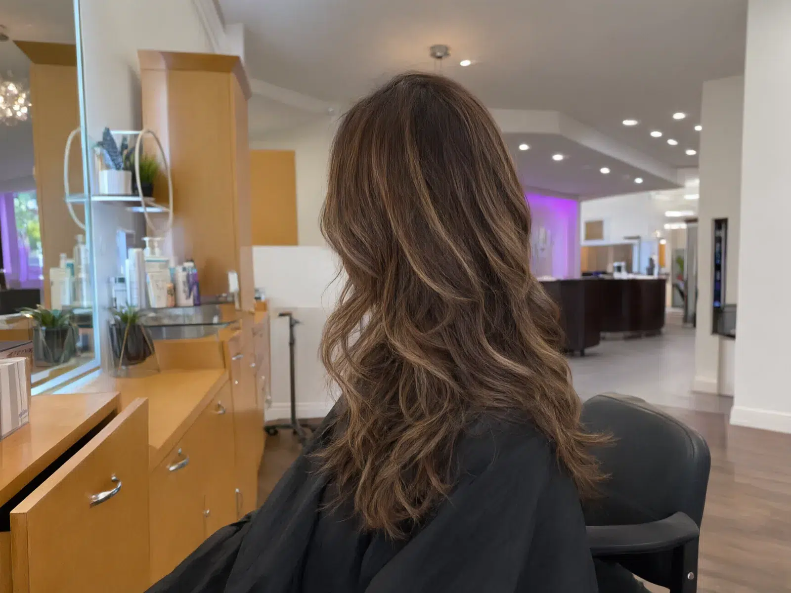 Chocolate brunette with caramel ribbons, loose waves, in the salon chair at Salon D