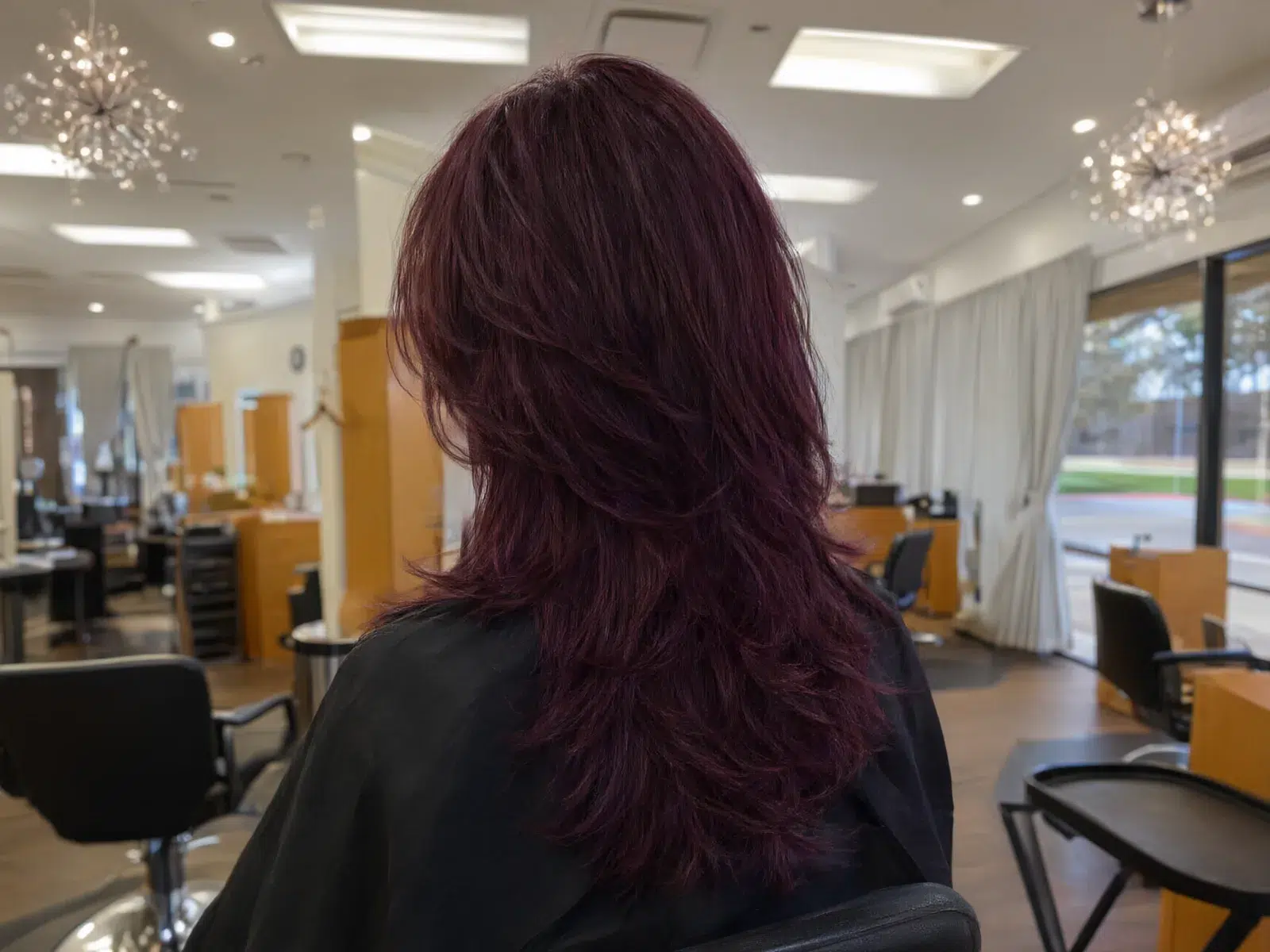 Close-up: deep burgundy layered cut, glossy