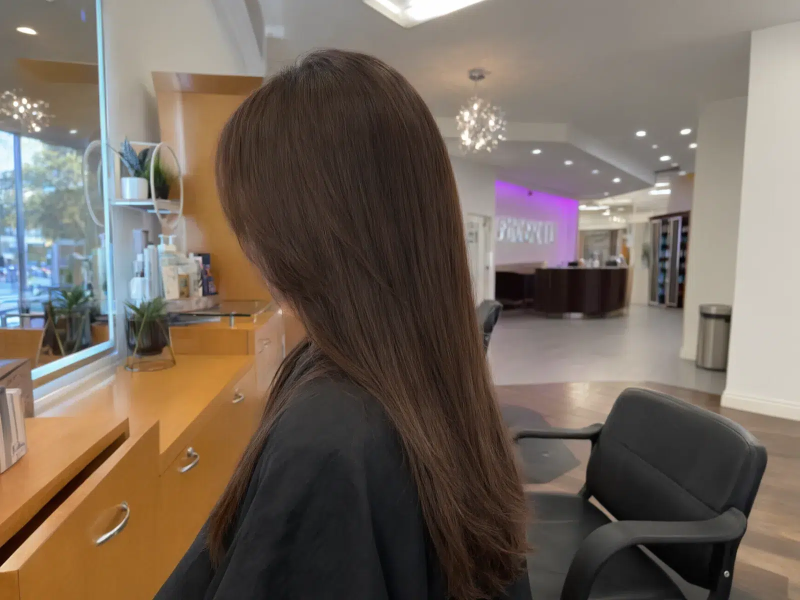 Close-up: straight, sleek, glass-smooth brunette hair after a keratin treatment