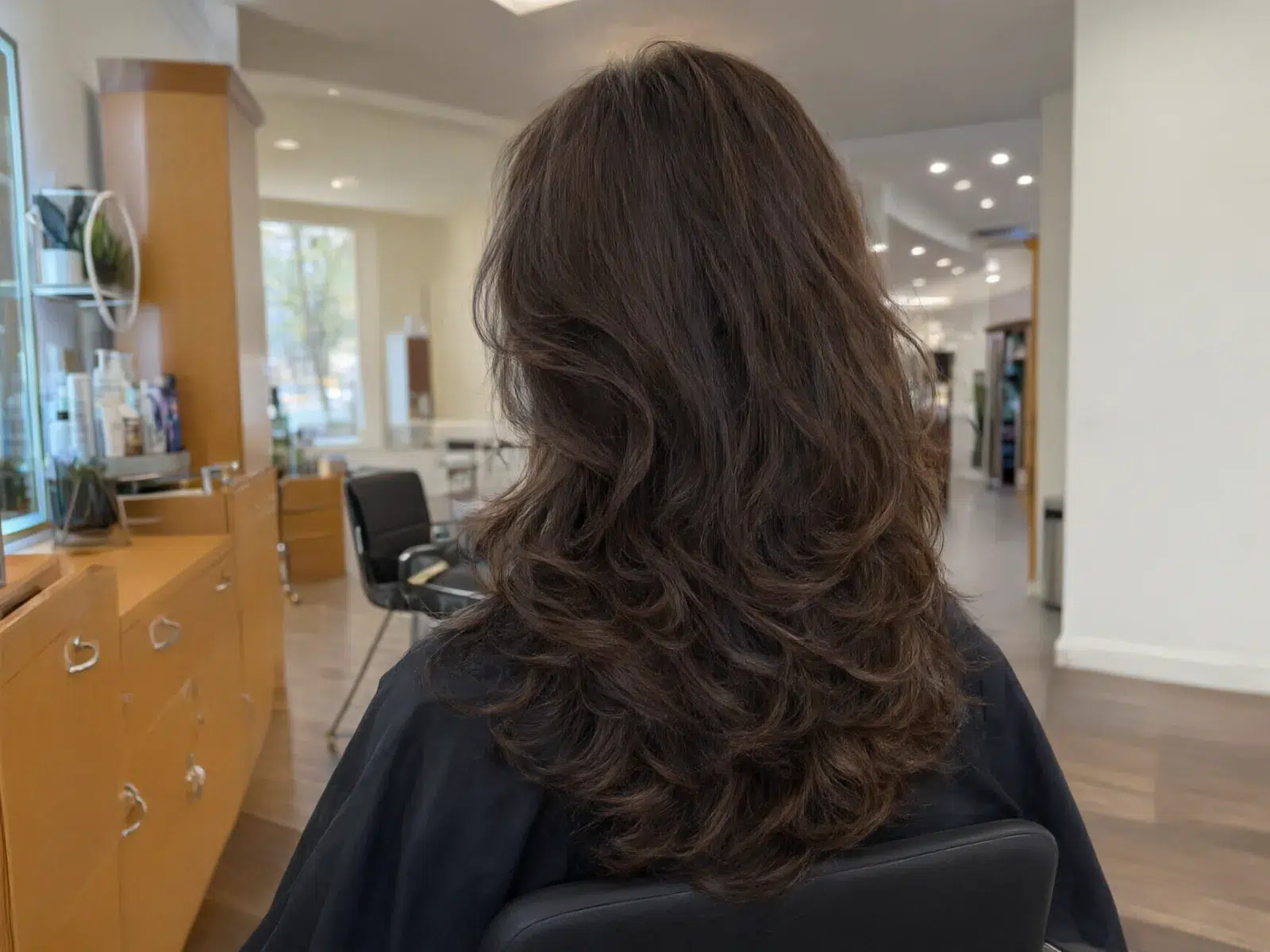 Close-up: voluminous espresso-brown blowout with bouncy ends