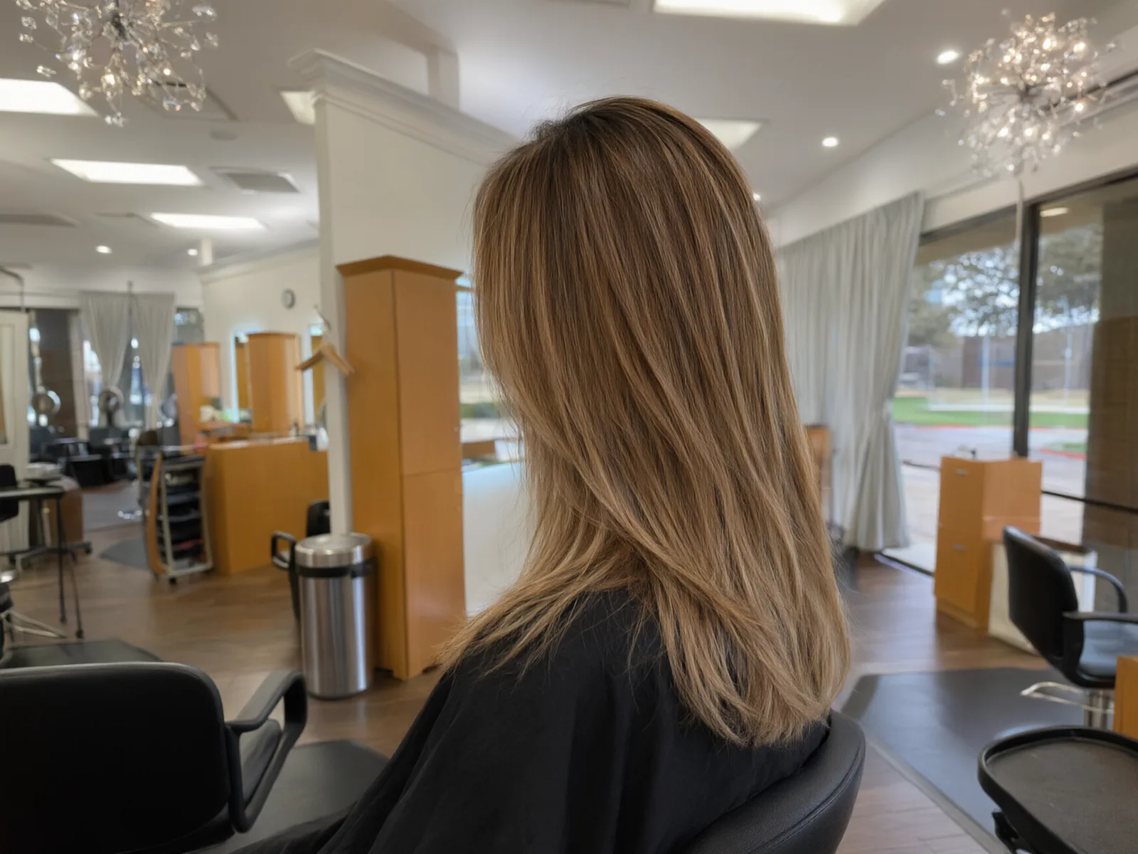 Soft hand-painted balayage in honey and caramel tones, blended at the roots, in the salon chair at Salon D